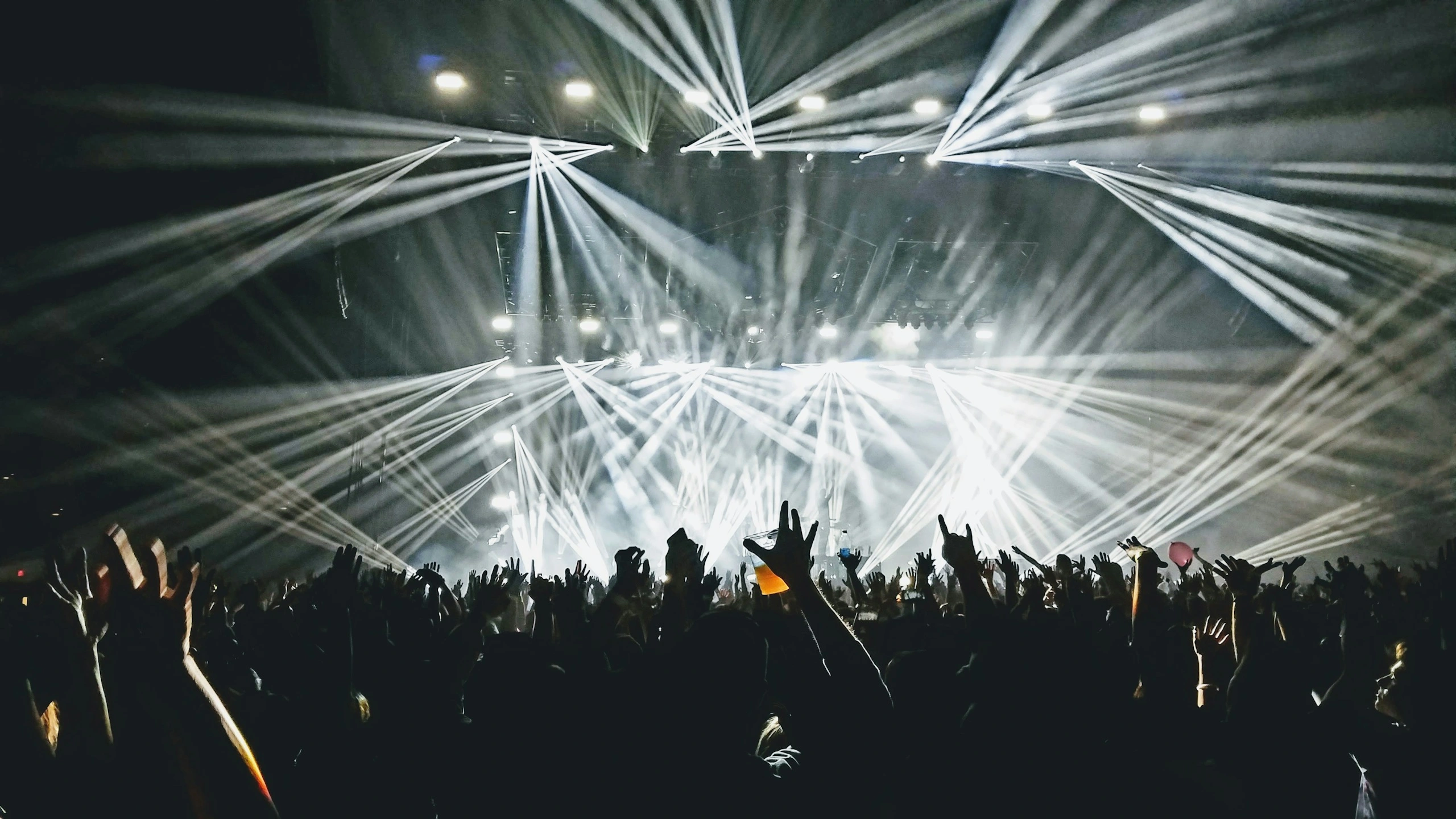 Public d’un concert sous des faisceaux de lumière.
